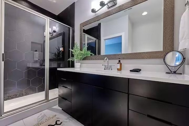 bathroom with marble finish floor, a stall shower, and vanity