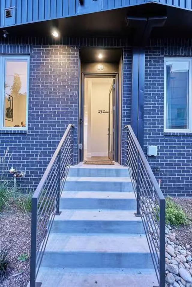 entrance to property featuring brick siding