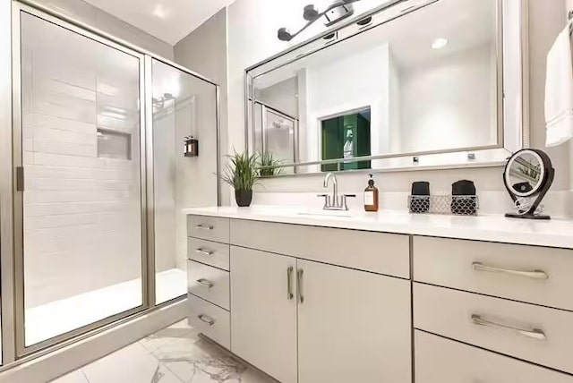 bathroom with marble finish floor, a stall shower, and vanity