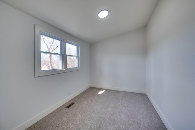 carpeted empty room featuring baseboards and visible vents