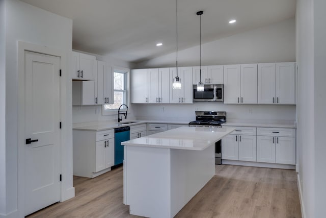 kitchen with white cabinetry, appliances with stainless steel finishes, light countertops, and pendant lighting