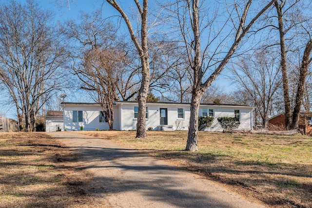 ranch-style home with driveway and a front yard