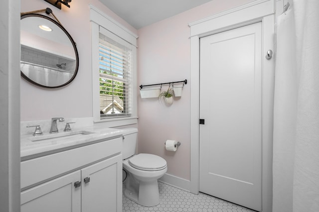 full bath with toilet, tile patterned flooring, baseboards, and vanity