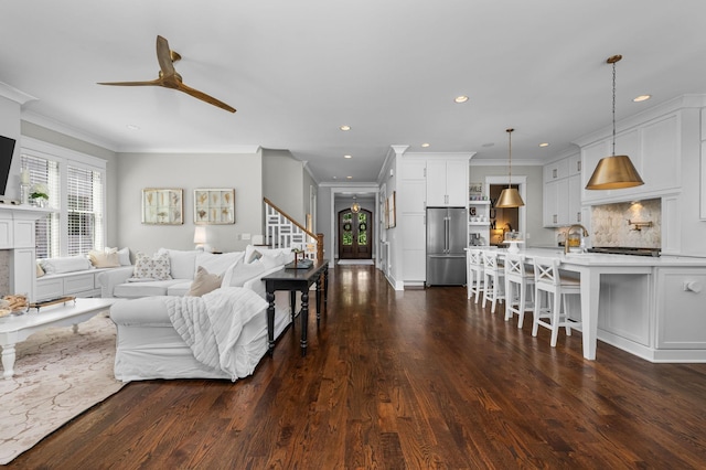 living room featuring ceiling fan, recessed lighting, dark wood-style flooring, stairs, and ornamental molding