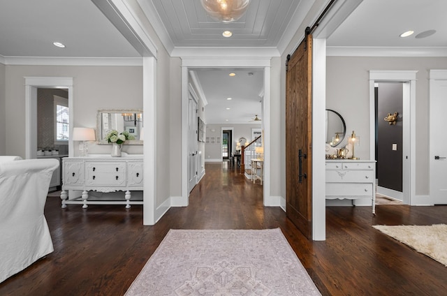 foyer entrance featuring a barn door, dark wood-type flooring, stairs, crown molding, and recessed lighting