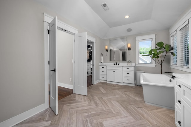 full bathroom featuring baseboards, a soaking tub, a spacious closet, vanity, and recessed lighting