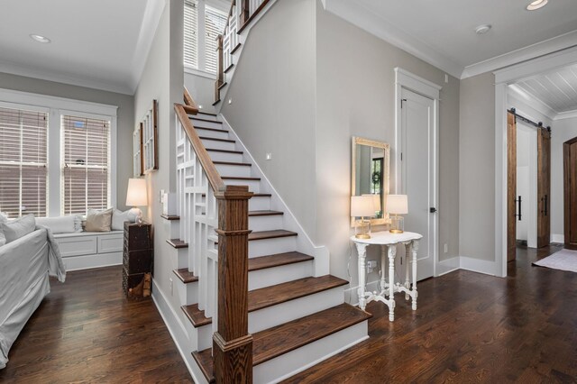 staircase with a barn door, recessed lighting, wood finished floors, baseboards, and crown molding