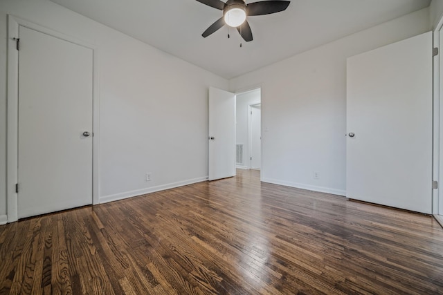 unfurnished bedroom with a ceiling fan, dark wood-style flooring, visible vents, and baseboards