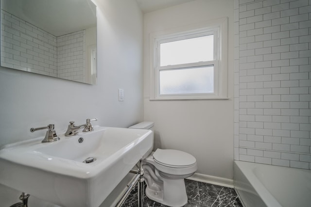 bathroom with marble finish floor, toilet, a sink,  shower combination, and baseboards