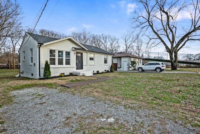 view of front of home with roof with shingles, a front lawn, and brick siding