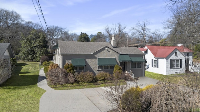 view of front of home with a chimney and a front lawn