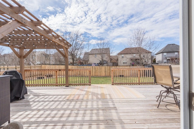 deck featuring a yard, a fenced backyard, and a pergola