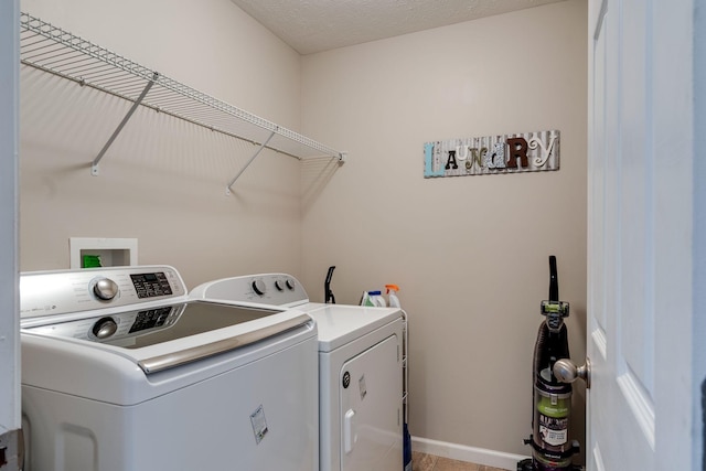 washroom featuring washer and dryer, laundry area, and baseboards