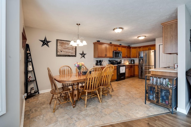 dining area featuring an inviting chandelier and baseboards