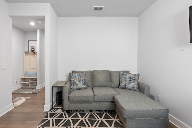 living area with visible vents, baseboards, and wood finished floors