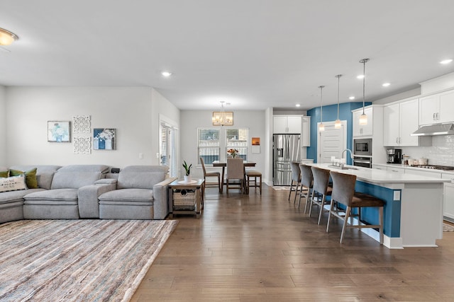 living room featuring dark wood finished floors, a notable chandelier, and recessed lighting