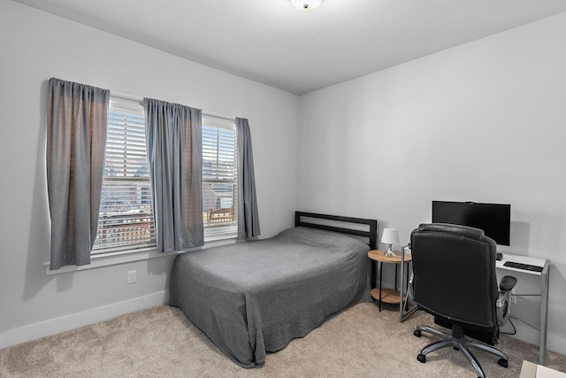 bedroom with baseboards and light colored carpet