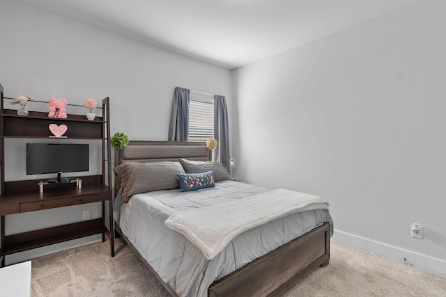 bedroom with light carpet and baseboards