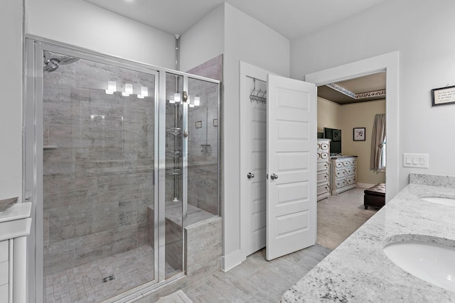 full bathroom with a sink, double vanity, and a shower stall