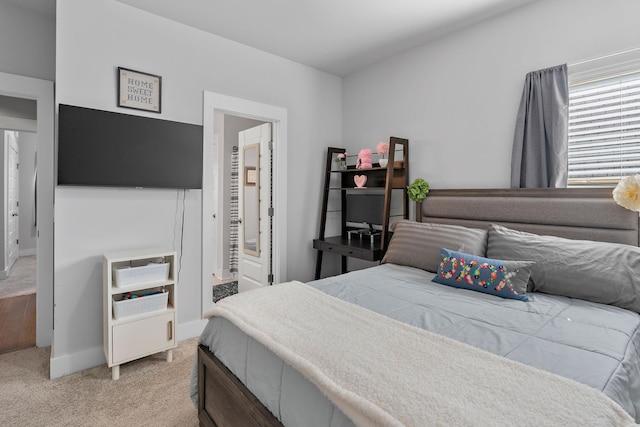 bedroom with light carpet and baseboards