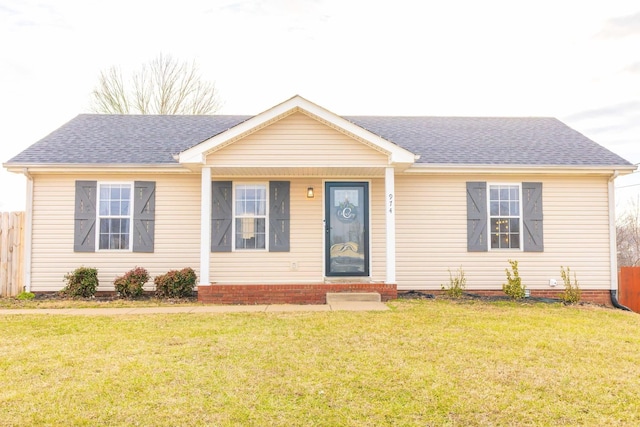 ranch-style house with a shingled roof, fence, and a front yard