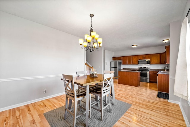 dining area featuring baseboards, stairway, light wood finished floors, and an inviting chandelier