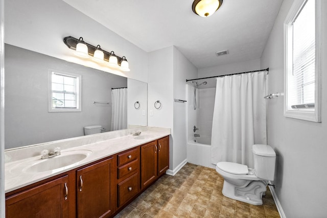 bathroom featuring toilet, shower / bath combo, visible vents, and a sink