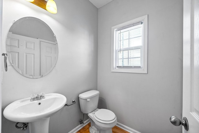 bathroom with a sink, toilet, and baseboards