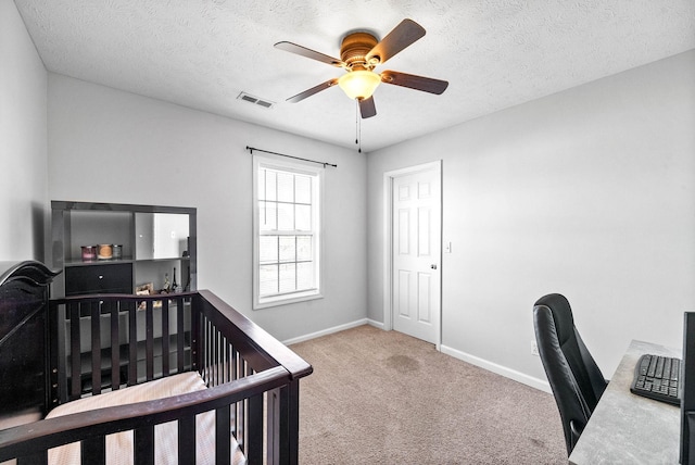 carpeted bedroom featuring a textured ceiling, ceiling fan, visible vents, and baseboards