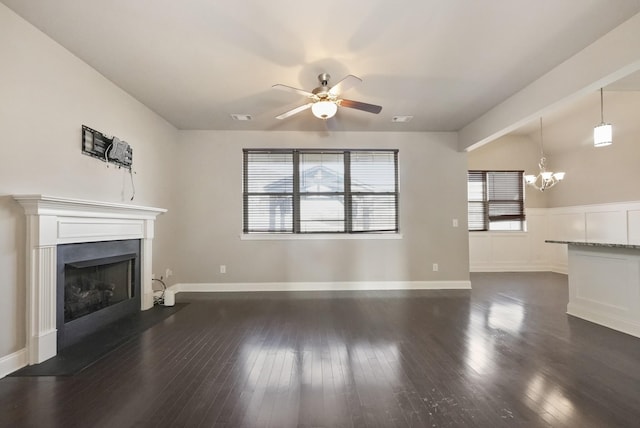 unfurnished living room with plenty of natural light, a fireplace, visible vents, and dark wood-style flooring