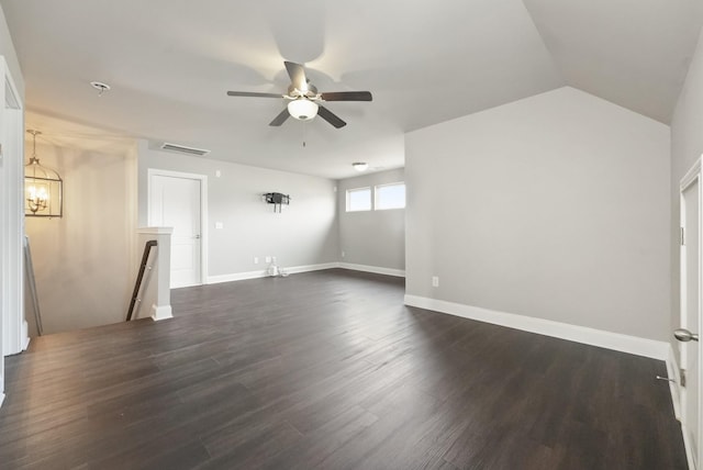 unfurnished living room featuring lofted ceiling, dark wood-style flooring, ceiling fan with notable chandelier, and baseboards