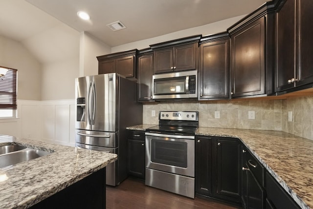 kitchen featuring light stone countertops, dark wood-style floors, visible vents, and stainless steel appliances