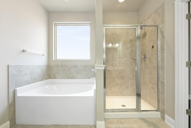 full bathroom with a garden tub, a shower stall, and tile patterned flooring