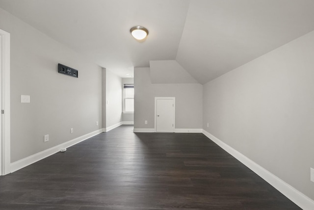 bonus room with vaulted ceiling, baseboards, and dark wood finished floors