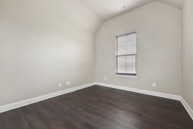 unfurnished room featuring visible vents, vaulted ceiling, baseboards, and dark wood finished floors