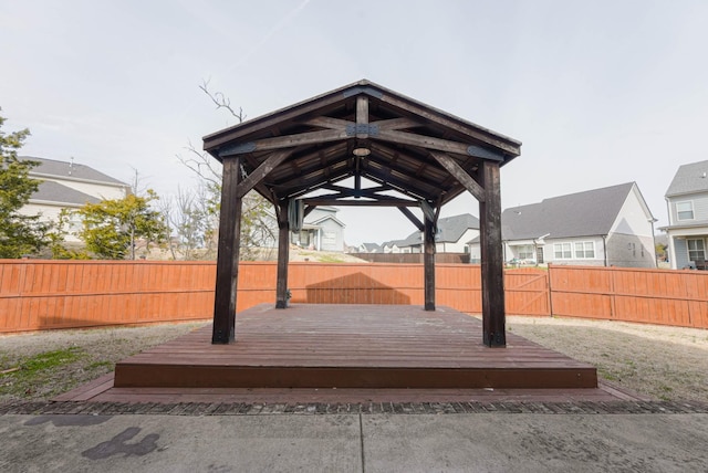 exterior space with a residential view, a fenced backyard, a wooden deck, and a gazebo