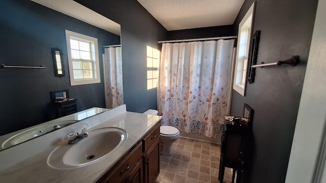 full bathroom featuring a textured ceiling, shower / bath combo, vanity, and toilet