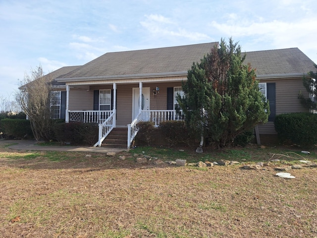 view of front of property featuring roof with shingles, a porch, and a front yard