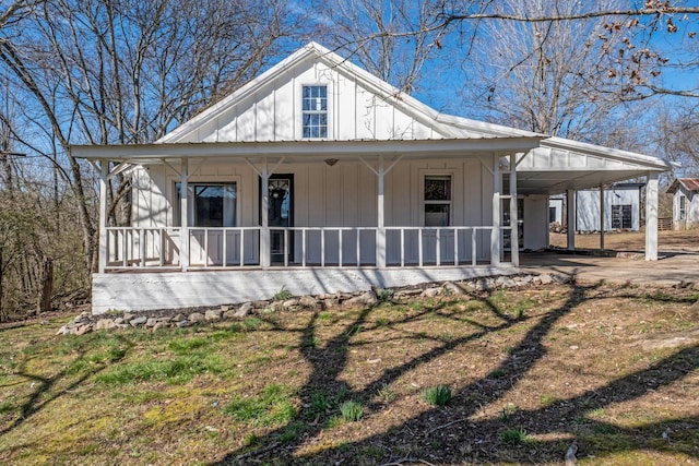 view of front of house with an attached carport, covered porch, board and batten siding, and metal roof