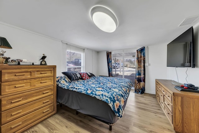 bedroom featuring visible vents, multiple windows, and light wood finished floors