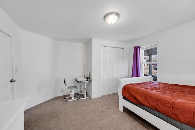 carpeted bedroom featuring a closet and baseboards