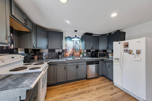 kitchen featuring tasteful backsplash, recessed lighting, appliances with stainless steel finishes, light wood-style floors, and a sink