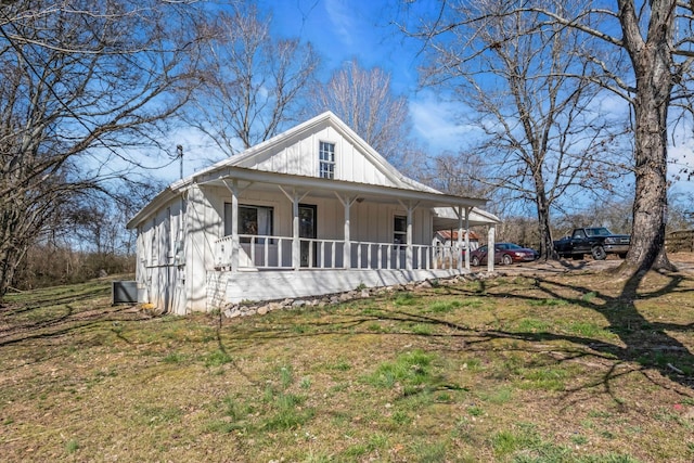 view of front of property featuring board and batten siding, a front lawn, and covered porch