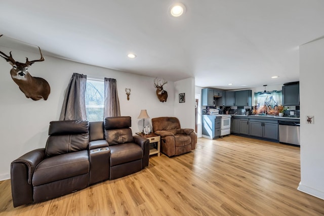 living area featuring recessed lighting, baseboards, and light wood-style floors