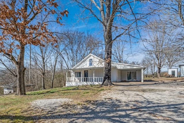 view of front of property featuring a porch, an attached carport, and driveway