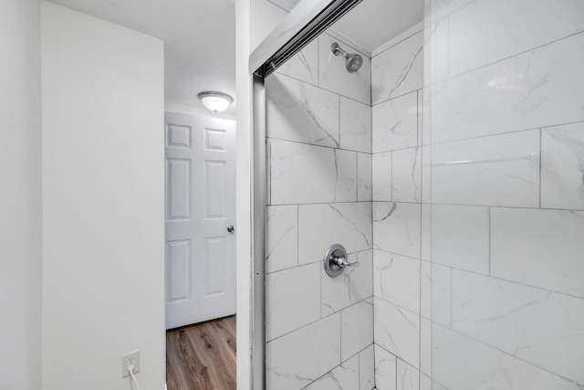 bathroom featuring tiled shower and wood finished floors