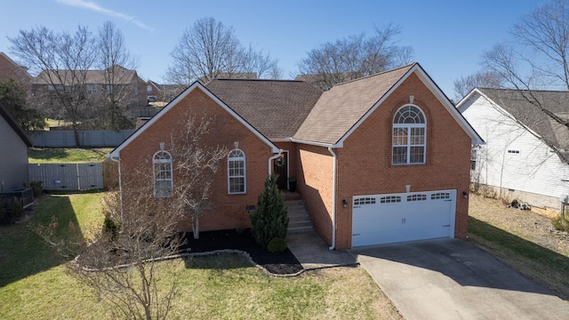 traditional-style house featuring a garage, concrete driveway, fence, a front lawn, and brick siding