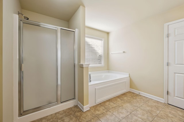 bathroom with a stall shower, a bath, baseboards, and tile patterned floors