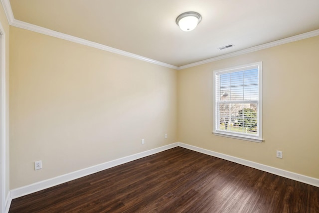 spare room featuring baseboards, visible vents, wood finished floors, and ornamental molding