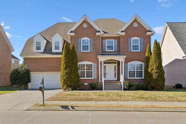 view of front of property with an attached garage, brick siding, driveway, roof with shingles, and a front lawn